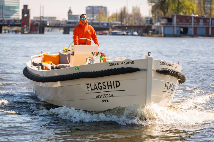 a small boat in a body of water with a city in the background