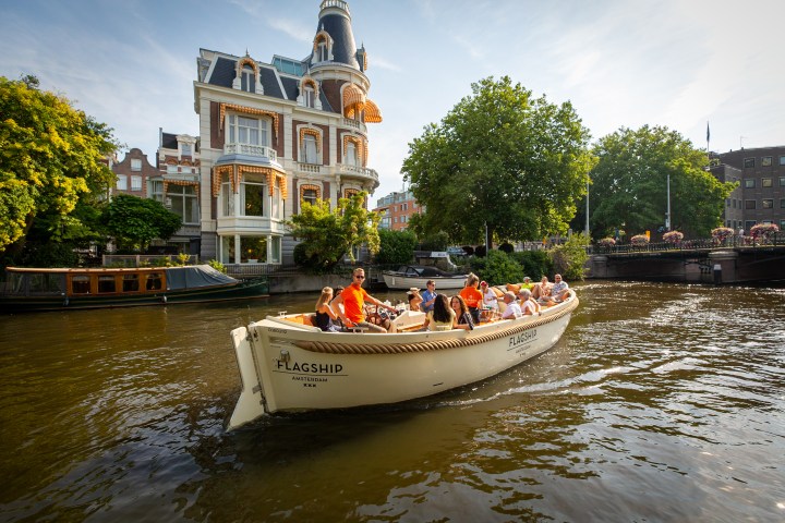 a small boat in a body of water with a city in the background